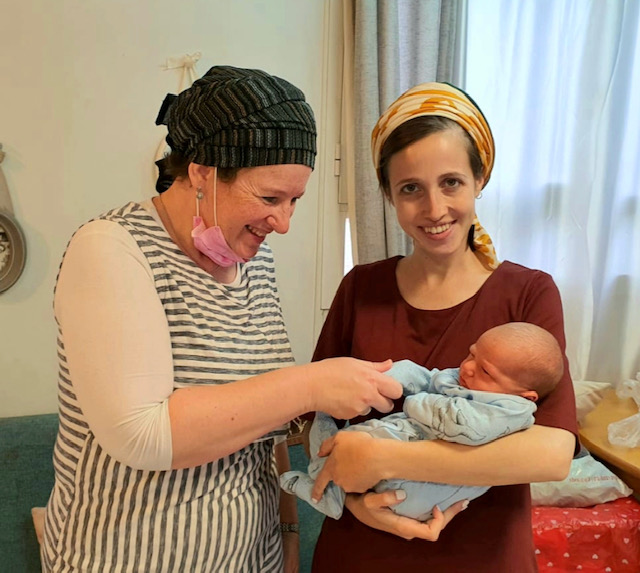 happy mother with infant and Sarah the midwife