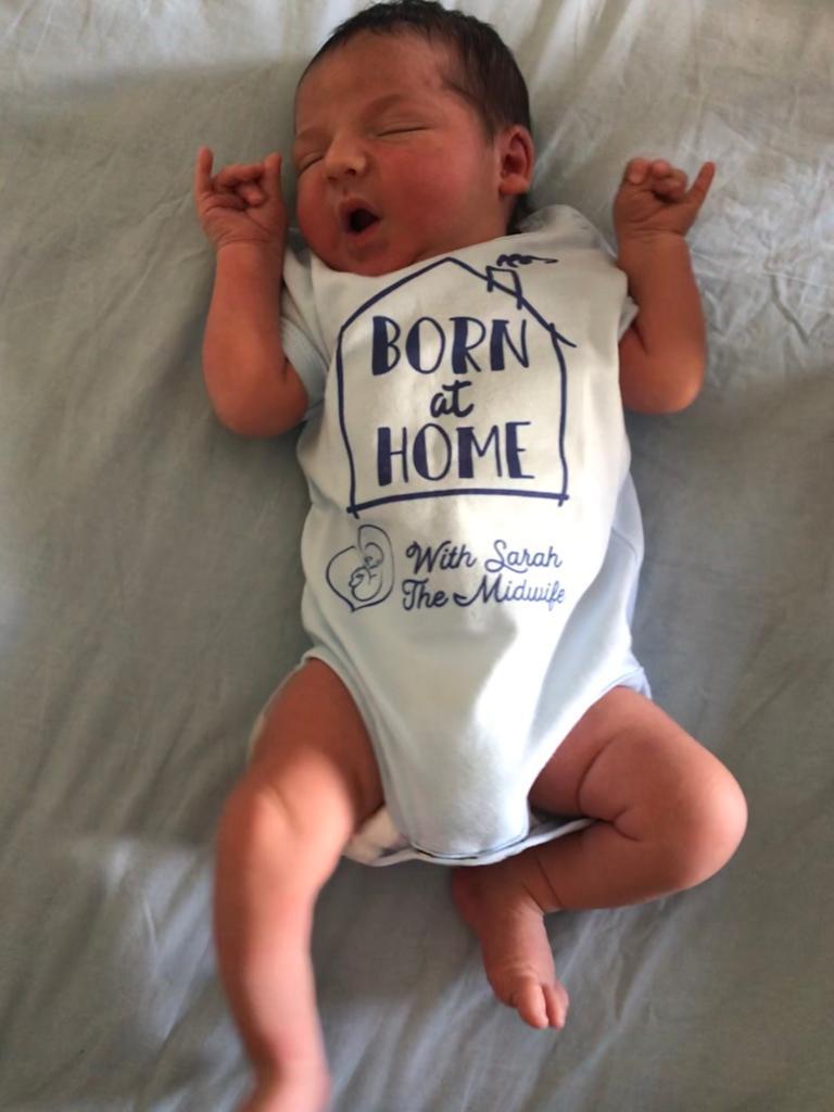infant in "Born at Home with Sarah the Midwife" onesie