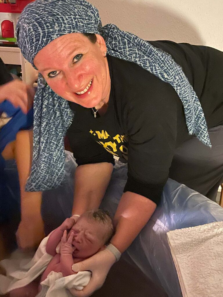 Sarah holding newborn baby in birthing pool
