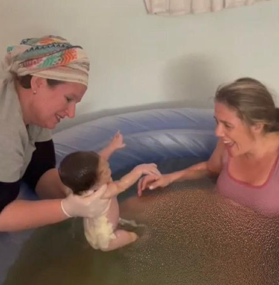 Sarah presents newborn to Mom in birthing pool